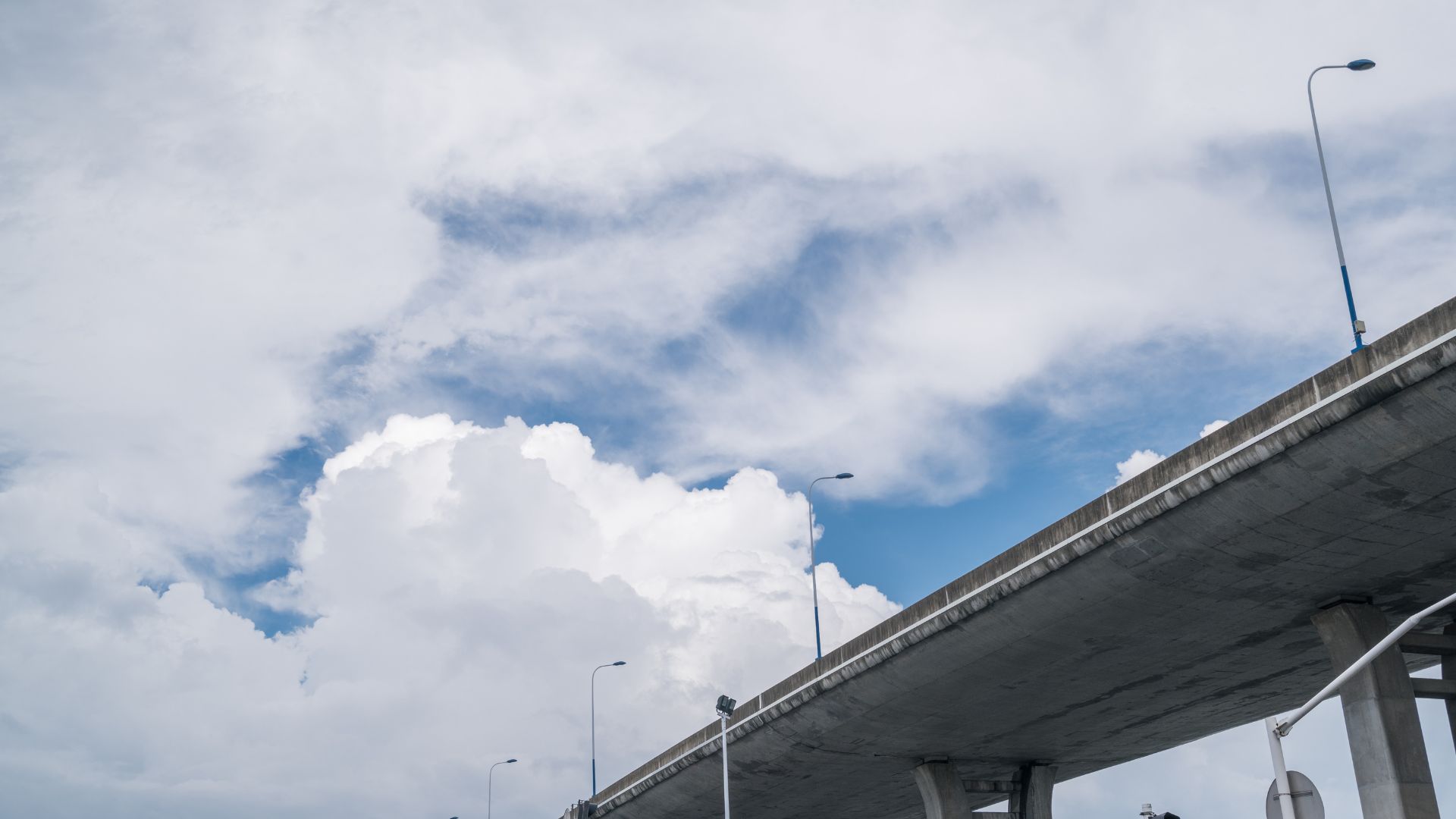 Shot of a blue and cloudy sky above a bridge